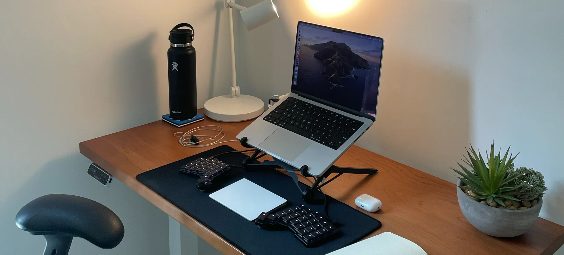 A photo of my desk with just a macbook, keyboard, and trackpad.